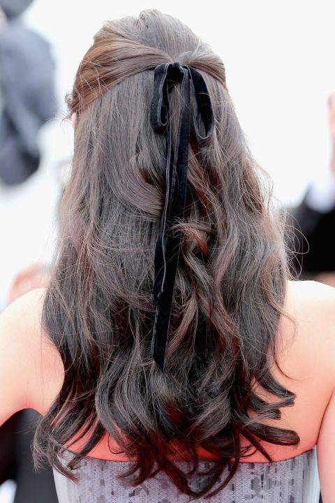 A velvet ribbon worn in a half-up, half-down style feels festive and feminine.
